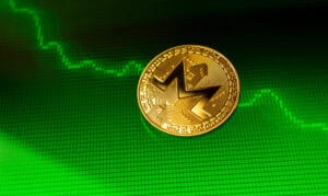 A Monero coin on a digital screen with a cryptocurrency chart in the background