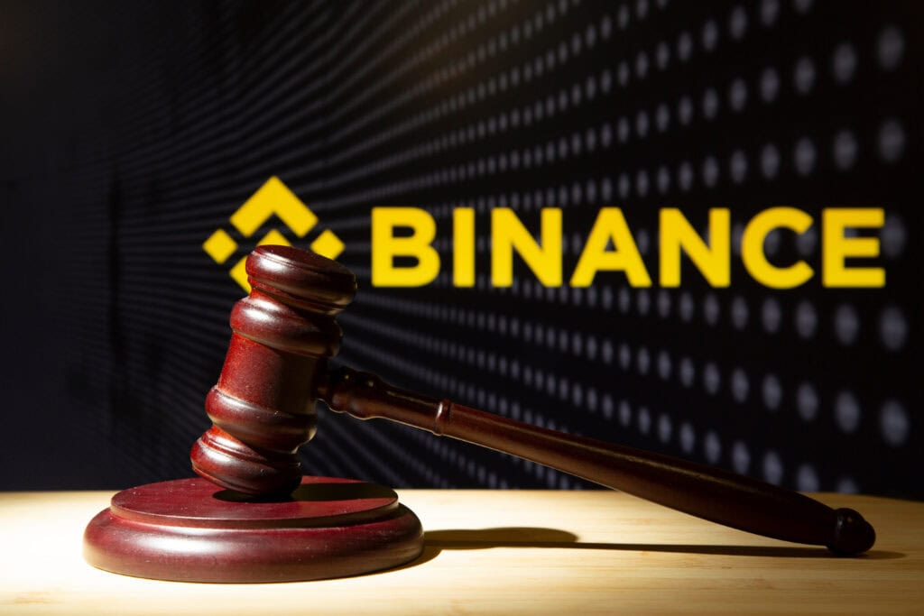 Binance and court session. Judicial hammer on the background of the logo.