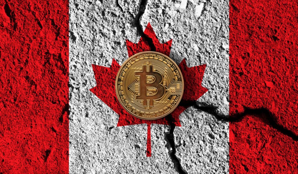 Bitcoin crypto currency coin with cracked Canada flag. Crypto restrictions.