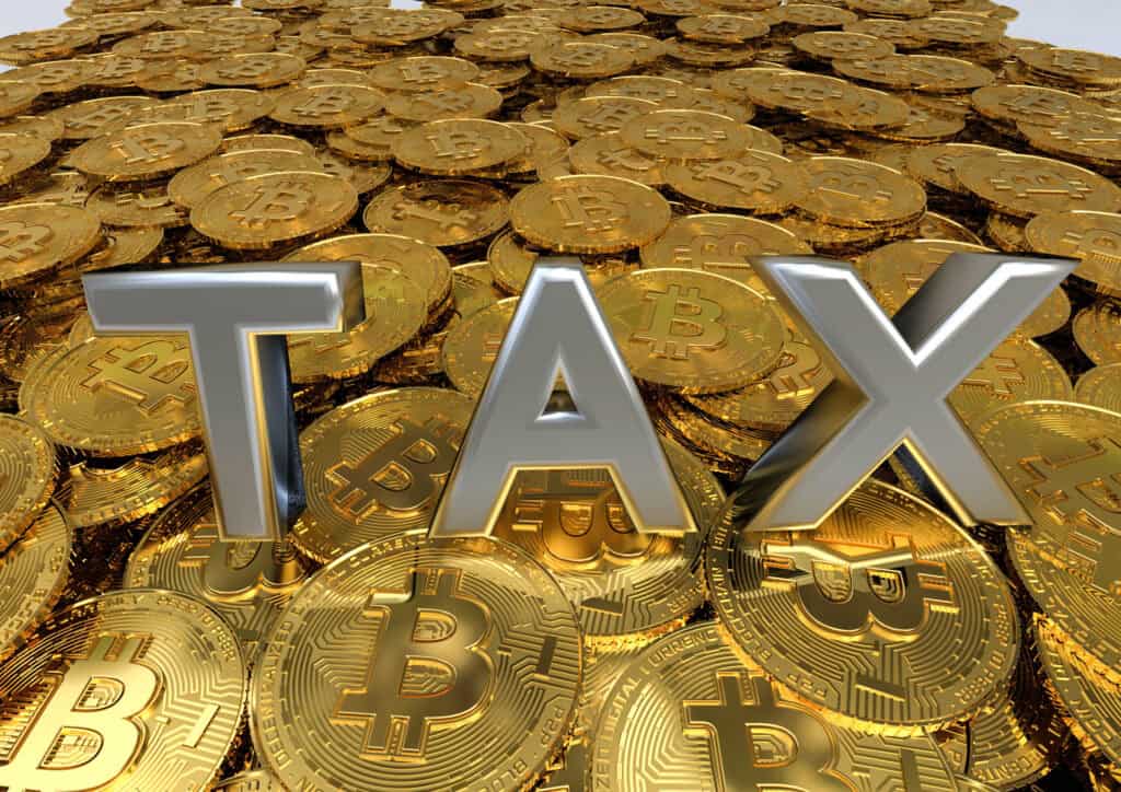 pile of coins with the text tax on top representing crypto taxes