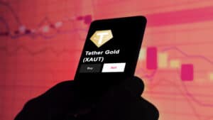 An investor's analyzing the Tether Gold (XAUT) coin on screen.