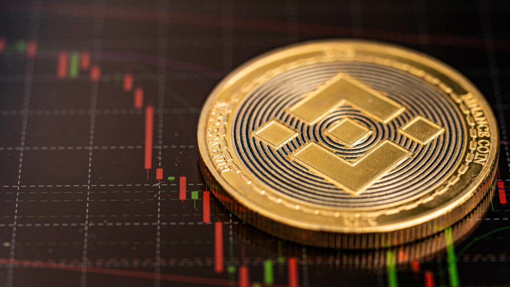 BNB coin is placed on the screen with a downtrend candlestick chart.