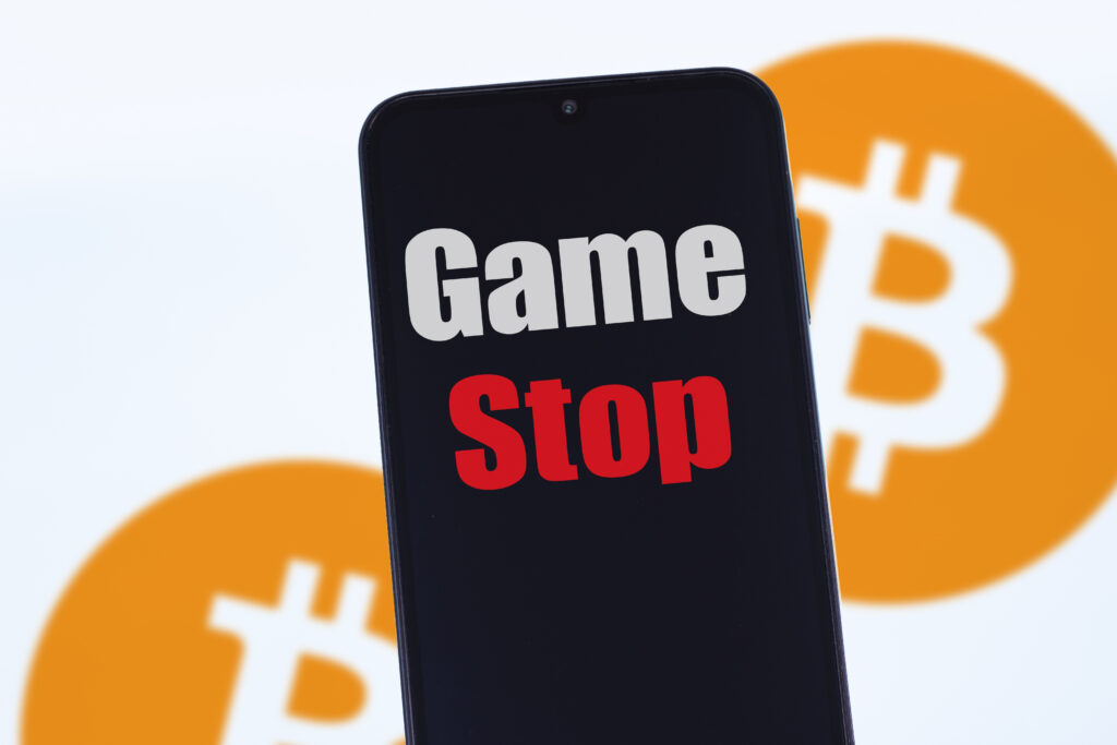 GameStop, in the blurred background, two instances of the bitcoin logo