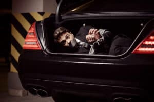Kidnapped businessman. Tied up businessman lying in the car trun