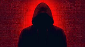 Mysterious Hooded Figure Silhouetted Against Red Background with Binary Code Symbolizing Cybersecurity and Intrigue