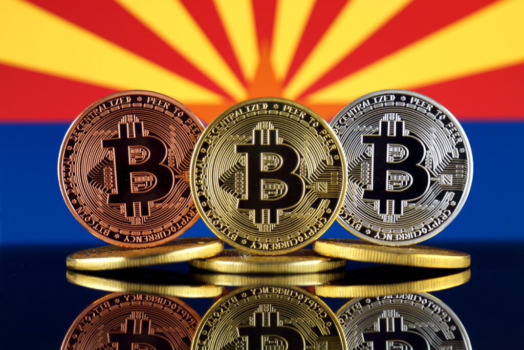 Physical version of Bitcoin (BTC) and Arizona State Flag.