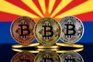 Physical version of Bitcoin (BTC) and Arizona State Flag.