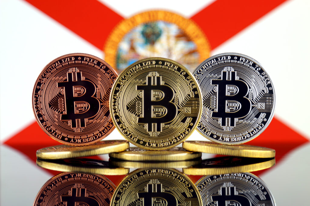 Physical version of Bitcoin (BTC) and Florida State Flag.