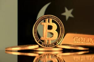 Physical version of Bitcoin, gold bar and Pakistan Flag.