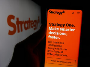 Person holding smartphone with web page of US company MicroStrategy Inc. on screen in front of logo.