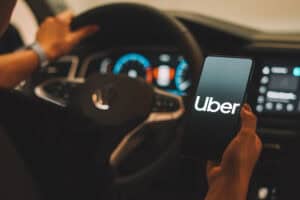 Uber logo is displayed on a smartphone screen.