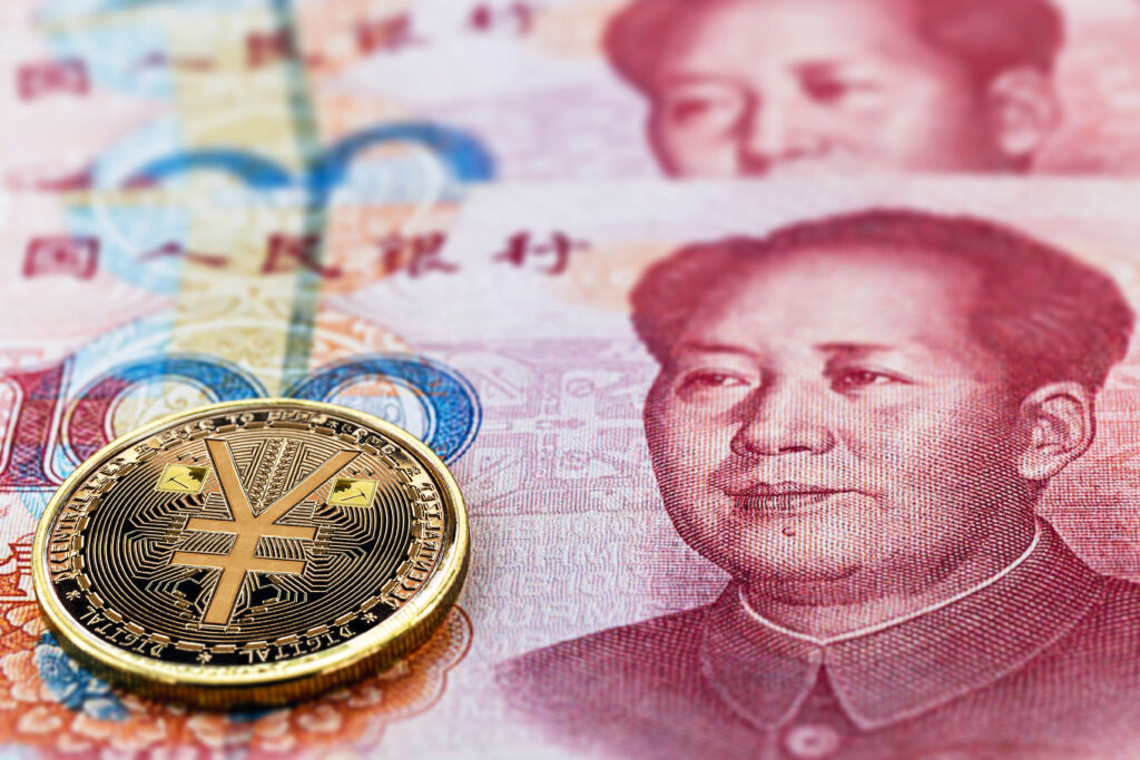 one hundred yuan banknotes, next to an e-RMB gold coin, digital version of the yuan. Concept of new digital currency of the popular republic of china