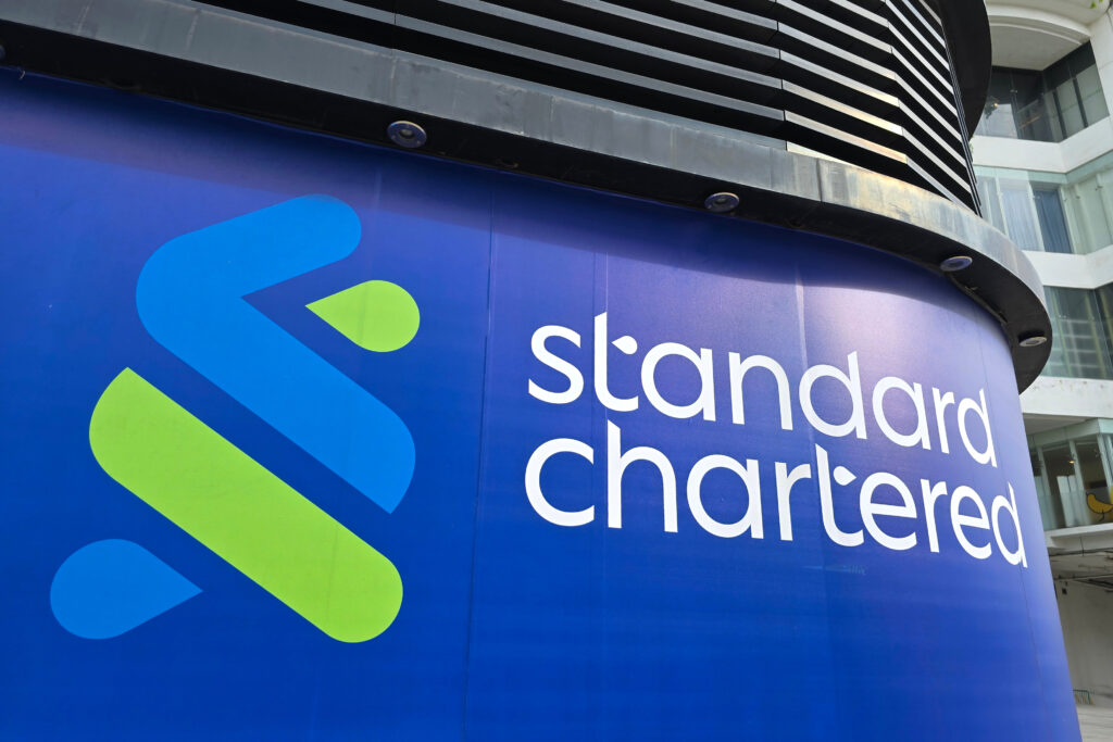 Close-up details of the Standard Chartered Bank logo and signage on the building exterior, showcasing the bank's modern branding.