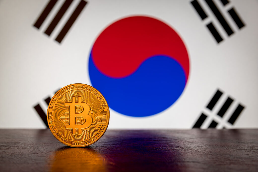 Golden physical Bitcoin with South Korea flag in the background