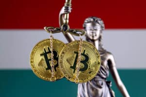 Symbol of law and justice, physical version of Bitcoin and Hungary Flag. Prohibition of cryptocurrencies, regulations, restrictions or security, protection, privacy.