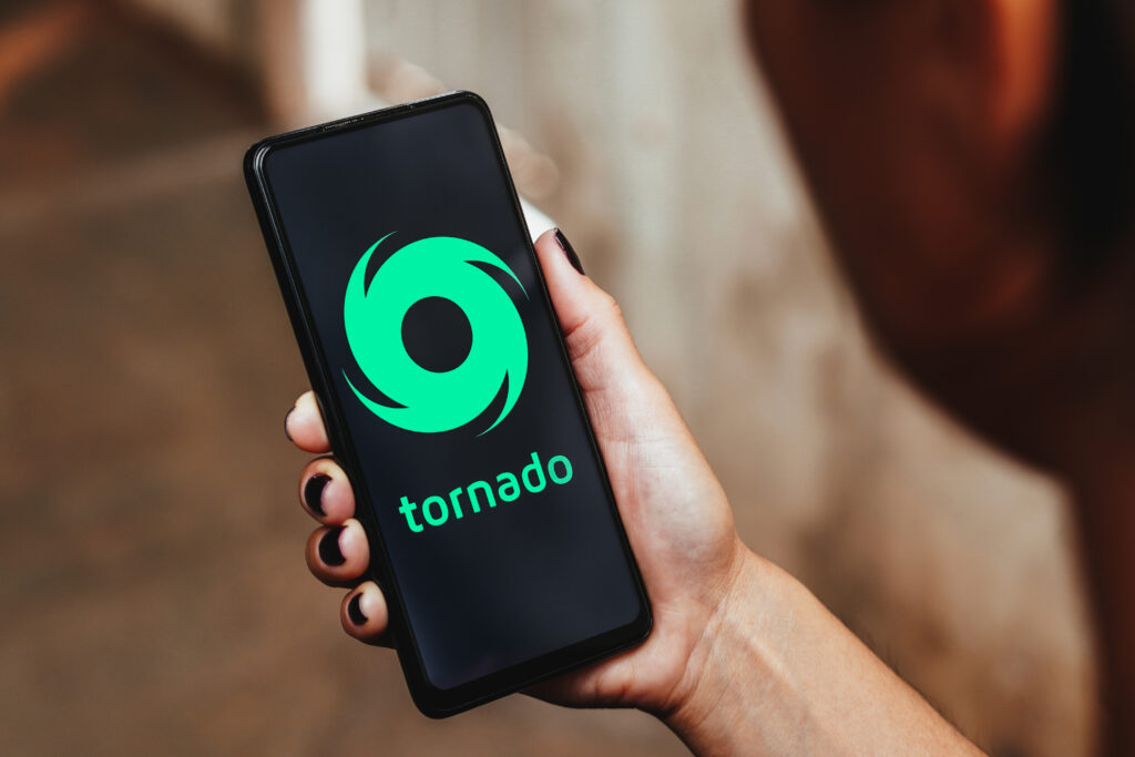 Tornado Cash logo is displayed on a smartphone screen.
