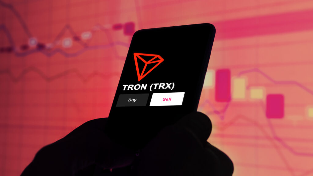 An investor's analyzing the TRON (TRX) coin on screen.