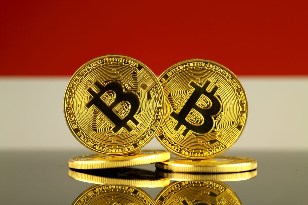 Physical version of Bitcoin and Indonesia Flag. Close up.