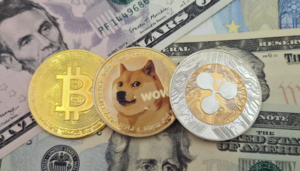 Photos of Bitcoin, Dogecoin, and XRP on the US dollar.