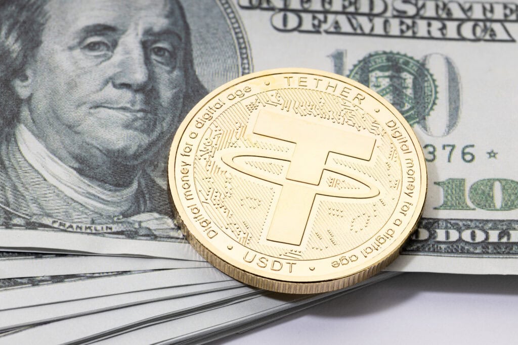 Tether USDT coin on stacked dollar banknotes.