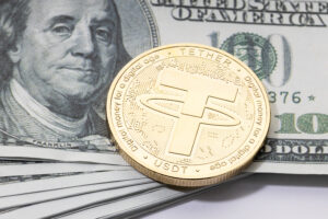 Tether USDT coin on stacked dollar banknotes.