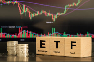 Wooden cubes with an ETF icon on a stock chart background